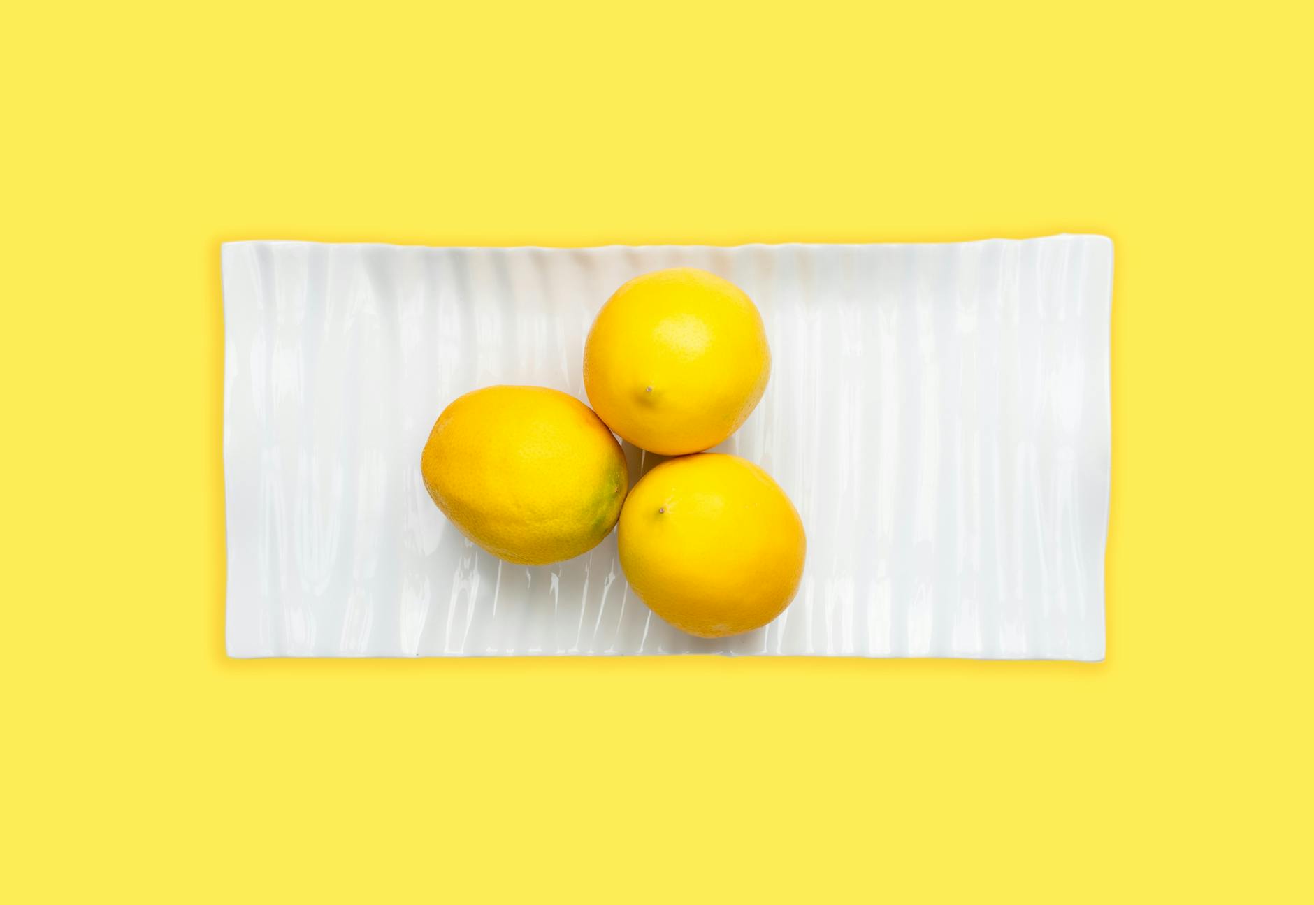 A young couple standing together indoors, holding a lemon vibrator, symbolizing modern intimacy and partnership.
