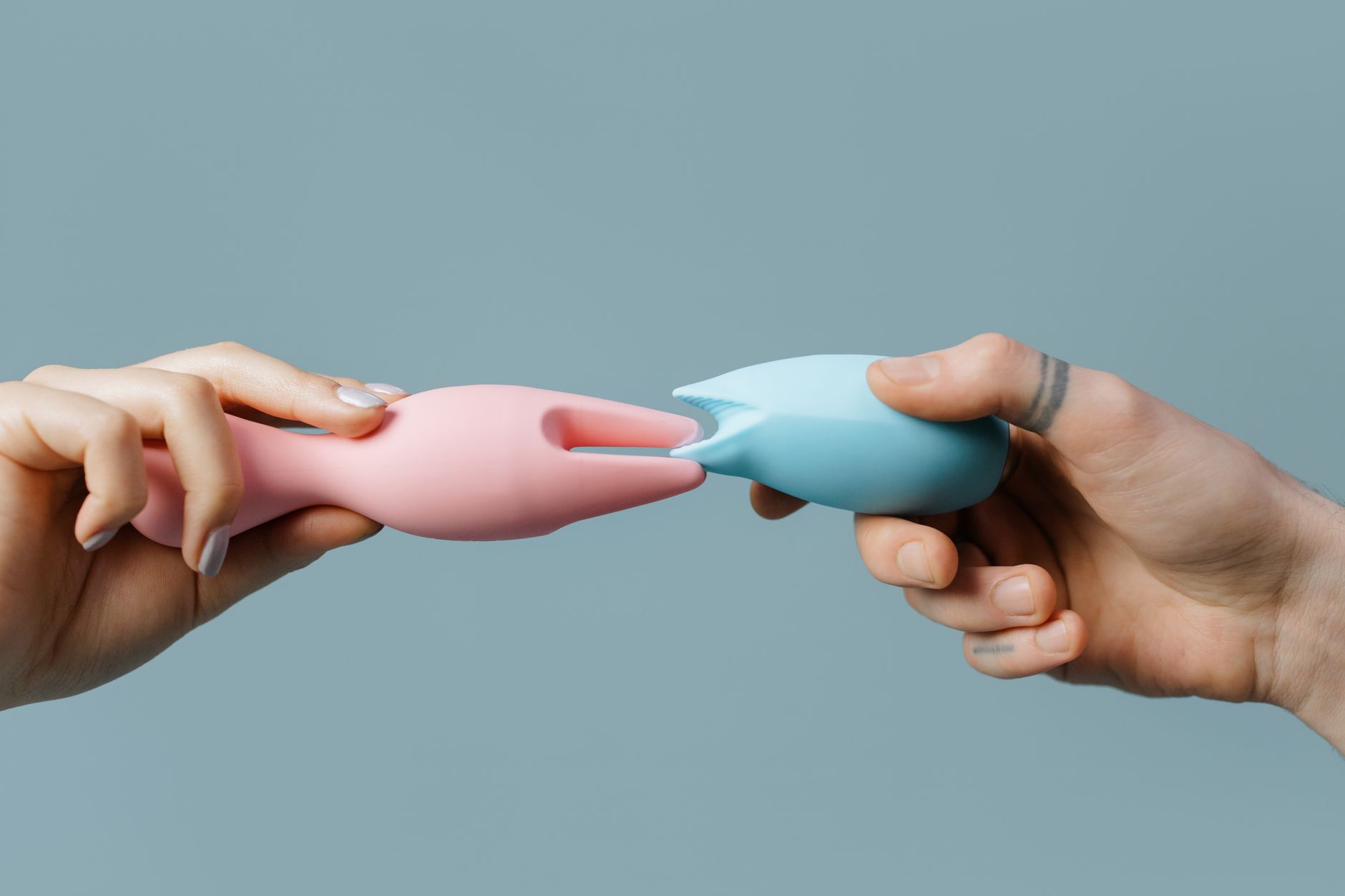 Hand holding a lemon-colored vibrator against a minimalist purple background
