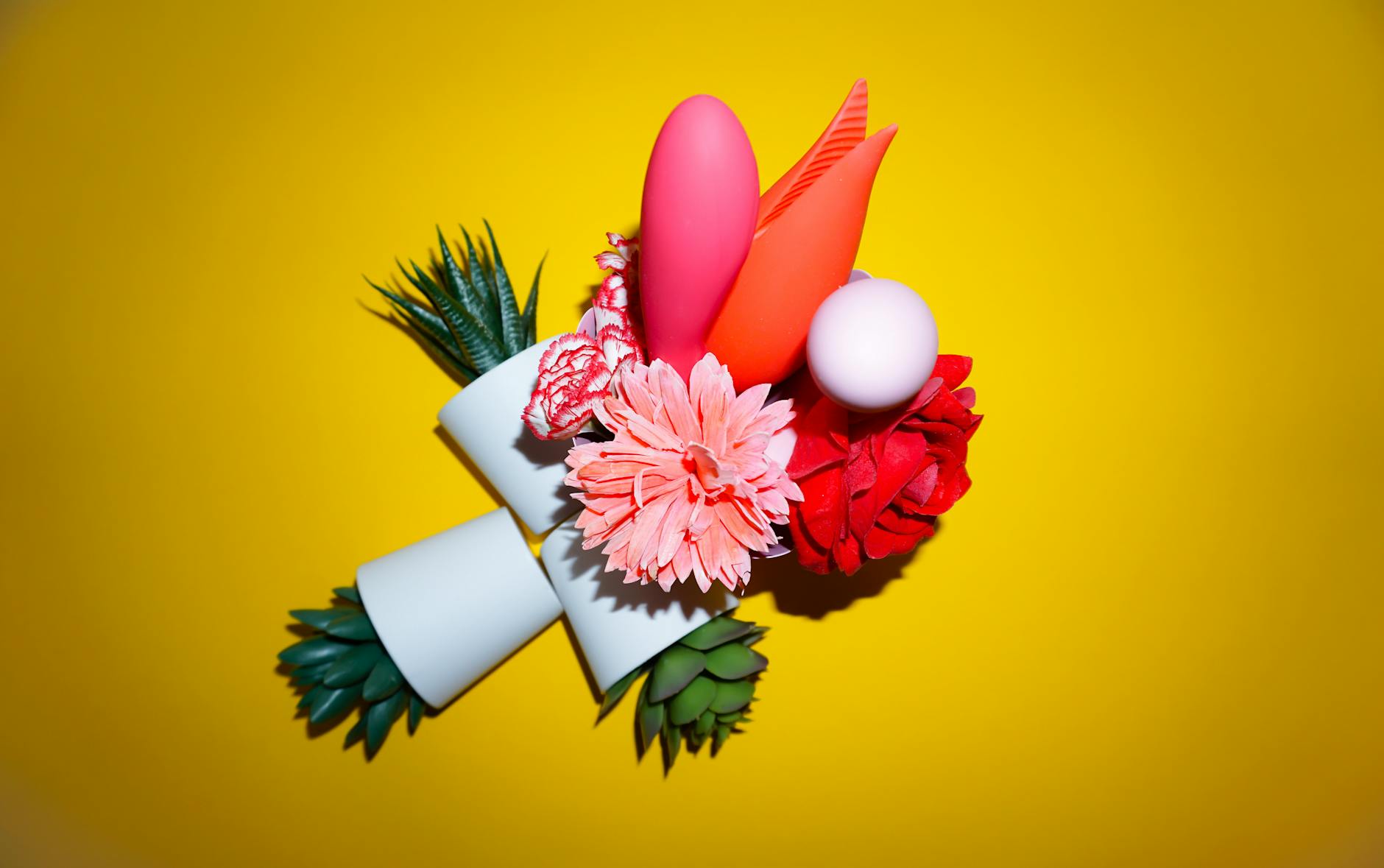 Vibrant arrangement of flowers and abstract objects on a bright yellow background.
