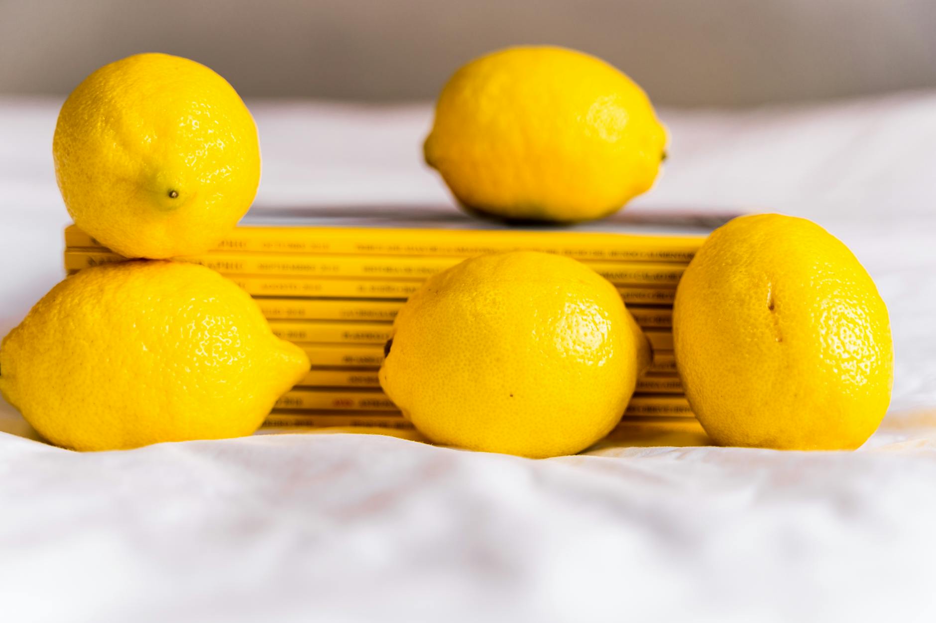 Fresh lemons arranged with books on white tablecloth, symbolizing renewal and fresh perspectives